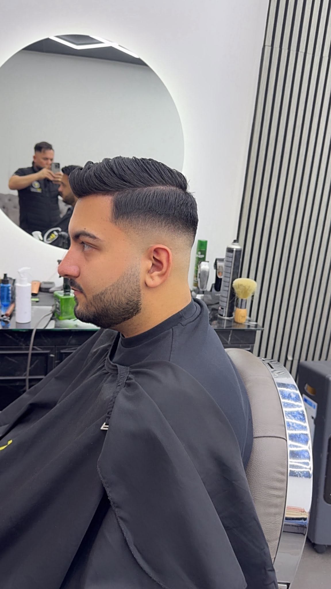 Side part pompadour with mid skin fade and tapered beard
